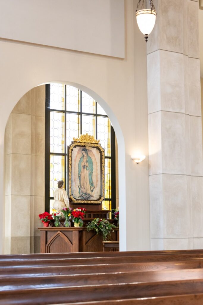 Image of Our Lady of Guadalupe with statue of Juan Diego through an archway before the California Catholic Wedding.
