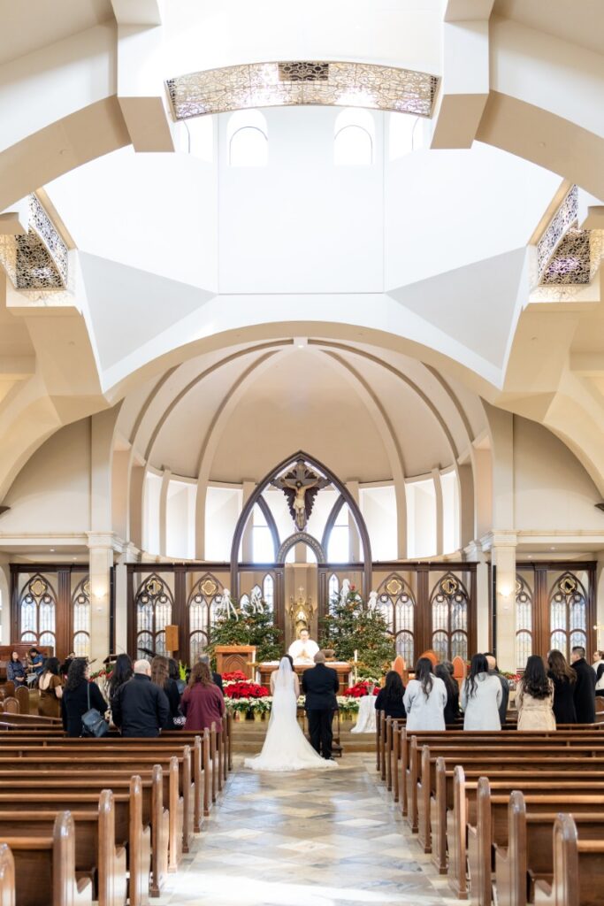 St. Stanislaus Catholic Church California Catholic Wedding photo of interior facing the altar with bride and groom at the altar.