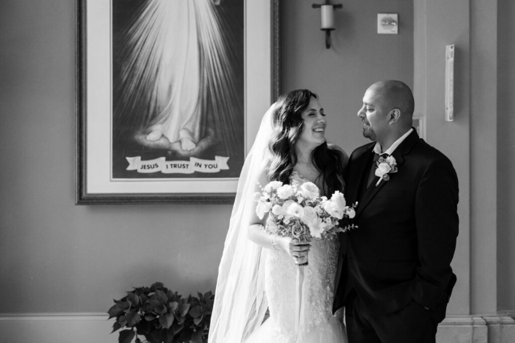 Catholic bride and groom in front of a Divine Mercy image.